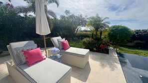 Two lounge chairs with cushions, a small table with a vase, and an umbrella. - Luxury 4BDR Casita 30 with Rooftop Lounge with Ocean View & private Jacuzzi (Diamante)