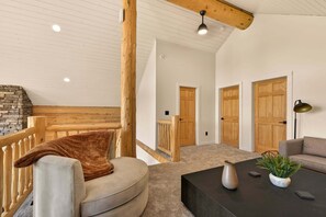 A cozy living room with a curved sofa, a coffee table, and a fireplace. - KABINO: Elevated Mountain Views 3 Stories Privacy Trails Yellowstone (Island Park)