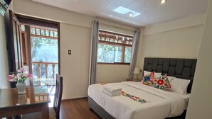 A bedroom with a bed, a table, chairs, and a window. - HOTEL PIEDRA BLANCA (Ollantaytambo)
