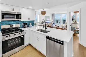 A modern kitchen with white cabinetry, a stainless steel dishwasher, and a built-in oven. - Remodeled Coastal Retreat with Breathtaking Views (North Myrtle Beach)