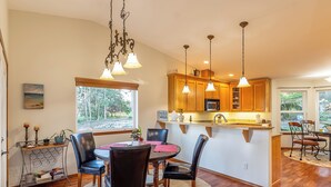 A modern kitchen with wooden cabinets, a central island, and pendant lighting.