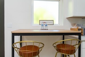 Un petit coin cuisine avec une fenêtre, deux chaises et une table.