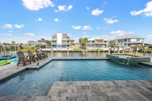 A swimming pool with lounge chairs and a view of a marina with boats. - PRIVATE HEATED POOL & SPA, PRIVATE BEACH, VOLLEYBALL & PICKLEBALL. BOAT DOCK (Pensacola)