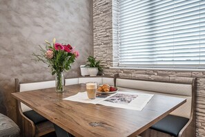 Ein Holztisch mit einer Blumenvase, einer Kaffeetasse und Croissants.