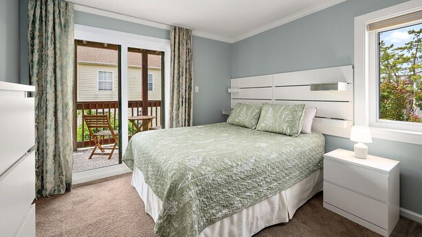 Een slaapkamer met een bed, nachtkastje en raam.