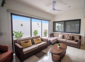 Ein Wohnzimmer mit einer Couch, einem Couchtisch und einem Deckenventilator.