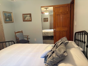 Un dormitorio con una cama, una silla y una puerta de madera.