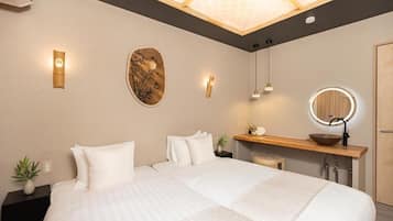 A modern hotel room with a large bed, bedside tables, a vanity with a mirror, and a ceiling light fixture.