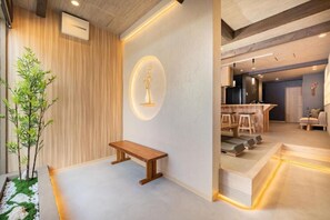A modern interior with a wooden bench, a wall-mounted light fixture, and a dining area with chairs and a table. - JAPAVISTA Yumeno (BAIKA, KONOHANA WARD)