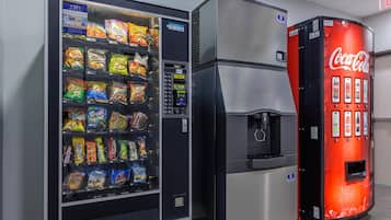 Un distributeur automatique de collations et un autre de boissons, notamment du Coca-Cola.