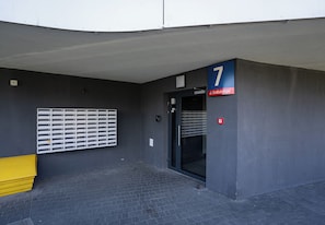 Une entrée d’immeuble avec une boîte aux lettres, une porte et une enseigne indiquant le numéro 7.