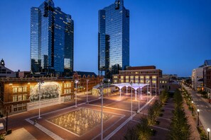 A cityscape with modern skyscrapers, a historic building with a mural, and a well-lit plaza. - Classic Quad Room | Downtown, 1.5 mi Stockyards Station, 1.6 mi to Rodeo (Fort Worth)
