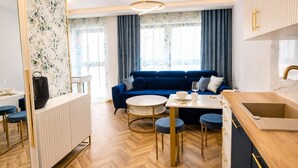 Ein stilvoller Wohnraum mit einem blauen Sofa, einem runden Couchtisch und Barhocker.