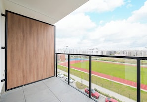 Ein Balkon mit Blick auf ein Sportfeld und Gebäude.