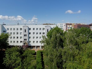 Un immeuble à plusieurs étages, doté d’une façade uniforme, de nombreuses fenêtres et surplombant un ciel dégagé.