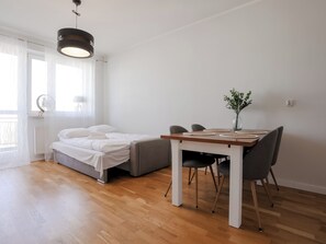 Une chambre à coucher comprenant un lit, une table de chevet et une petite table à manger avec des chaises.