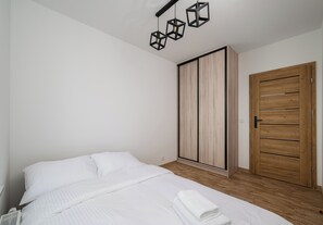 Ein Schlafzimmer mit einem Bett, einem Kleiderschrank und einer Tür.