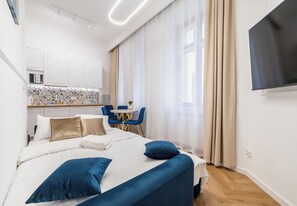 Ein modernes Hotelzimmer mit Bett, Schreibtisch und Fernseher.
