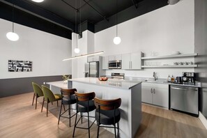 A modern kitchen with a central island, bar stools, stainless steel appliances, and pendant lighting. - 3 Bed w Private Patio, Mtn Views & Walk to Dining (Chattanooga)