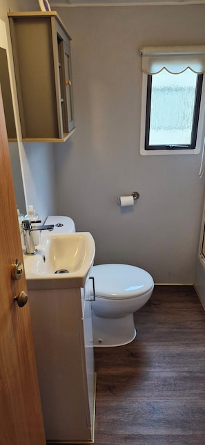 Ein Badezimmer mit Toilette, Waschbecken und Fenster.