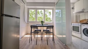 A modern kitchen with a dining area, wooden flooring, and large windows. - Deda Studio w. Smart TV · AC · washing machine (Bucharest)