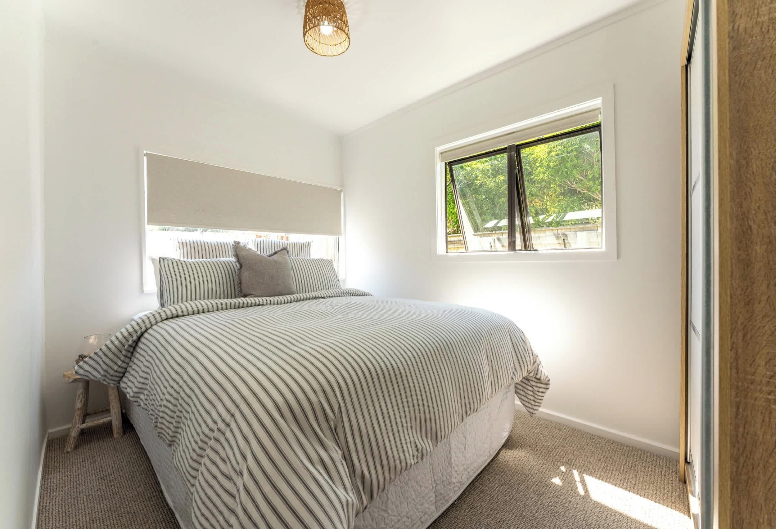 Una camera da letto con un letto, una finestra e una lampada a soffitto.