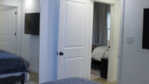 Ein Schlafzimmer mit einem Bett, einer Tür zu einem anderen Raum und einem Deckenventilator.