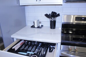 A kitchen with a white countertop, a stainless steel oven, and a drawer with utensils. - Luxury 2BR Near Medical District - Gated Parking & Sleeps 6 (Memphis)