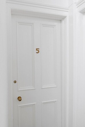 A white door with a brass doorknob and a number '5' on the door. - GuestReady - Bright Studio in Leith, Edinburgh (Edinburgh)