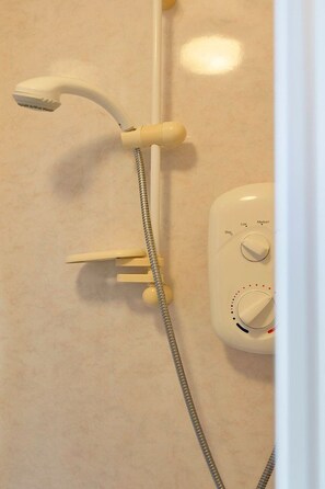 A shower with a handheld showerhead and a control panel with water temperature and flow settings. - GuestReady - Cosy Single Room in Leith, Edinburgh (Edinburgh)