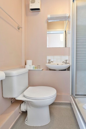 A small bathroom with a toilet, sink, and mirror. - GuestReady - Cosy Single Room in Leith, Edinburgh (Edinburgh)