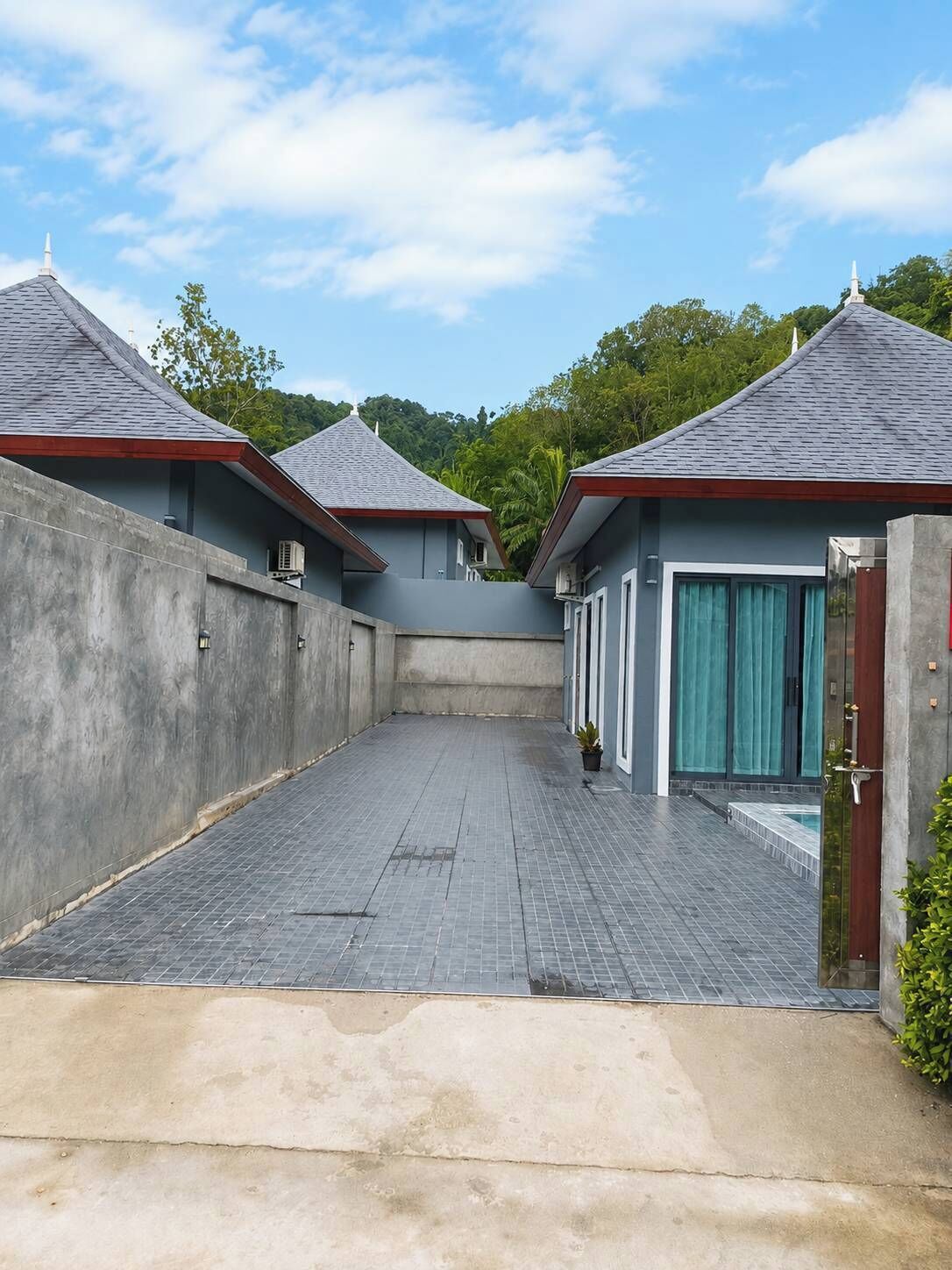 Un edificio moderno con un patio empinado, paredes de concreto y una zona de piscina.