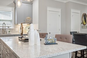 A kitchen with a marble countertop, a welcome sign, and a decorative globe. - Stay in style! Spacious Nash home near Broadway! (Nashville)