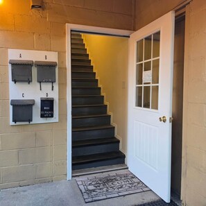 A staircase leading to a door with a sign above it. - Liberty Alley Hideaway 2 (Lawrenceburg)