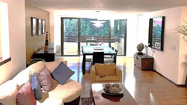 A spacious living room with a sofa, a coffee table, and a dining area with a table and chairs. - 70ft from the Tiffany's store in Polanco, near the World Cup, 2-bedroom apartment with a balcony. (Ciudad de México)