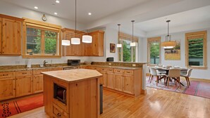 Una cocina moderna con armarios de madera, una isla central e iluminación colgante.