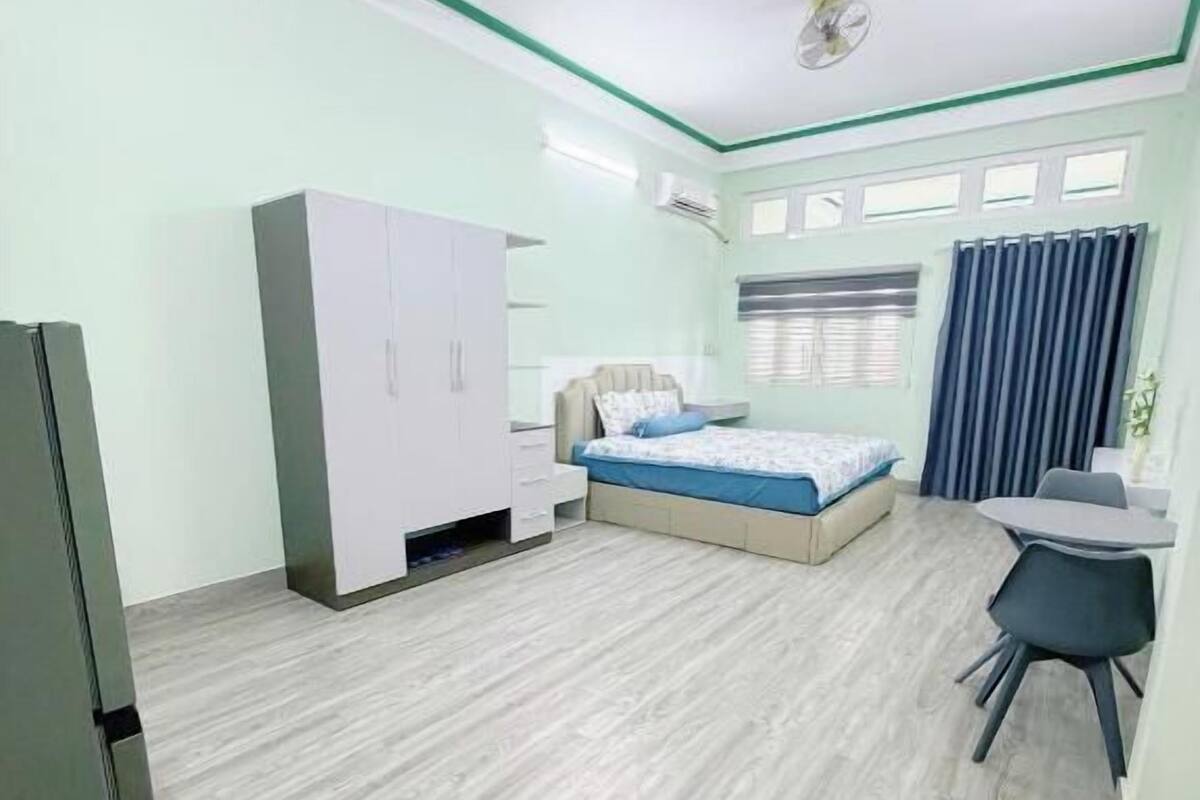 Una habitación con cama, escritorio, armario y ventilador de techo.