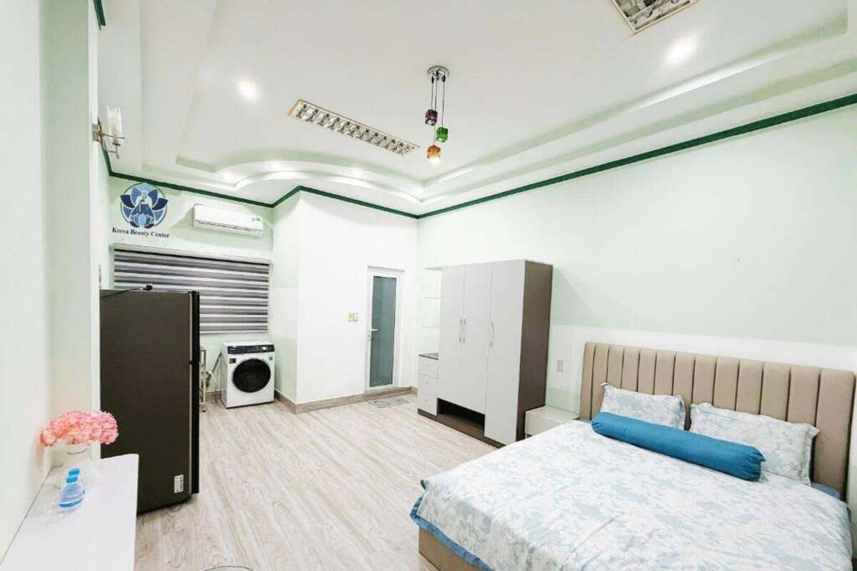 Un dormitorio con cama, armario y lavadora.