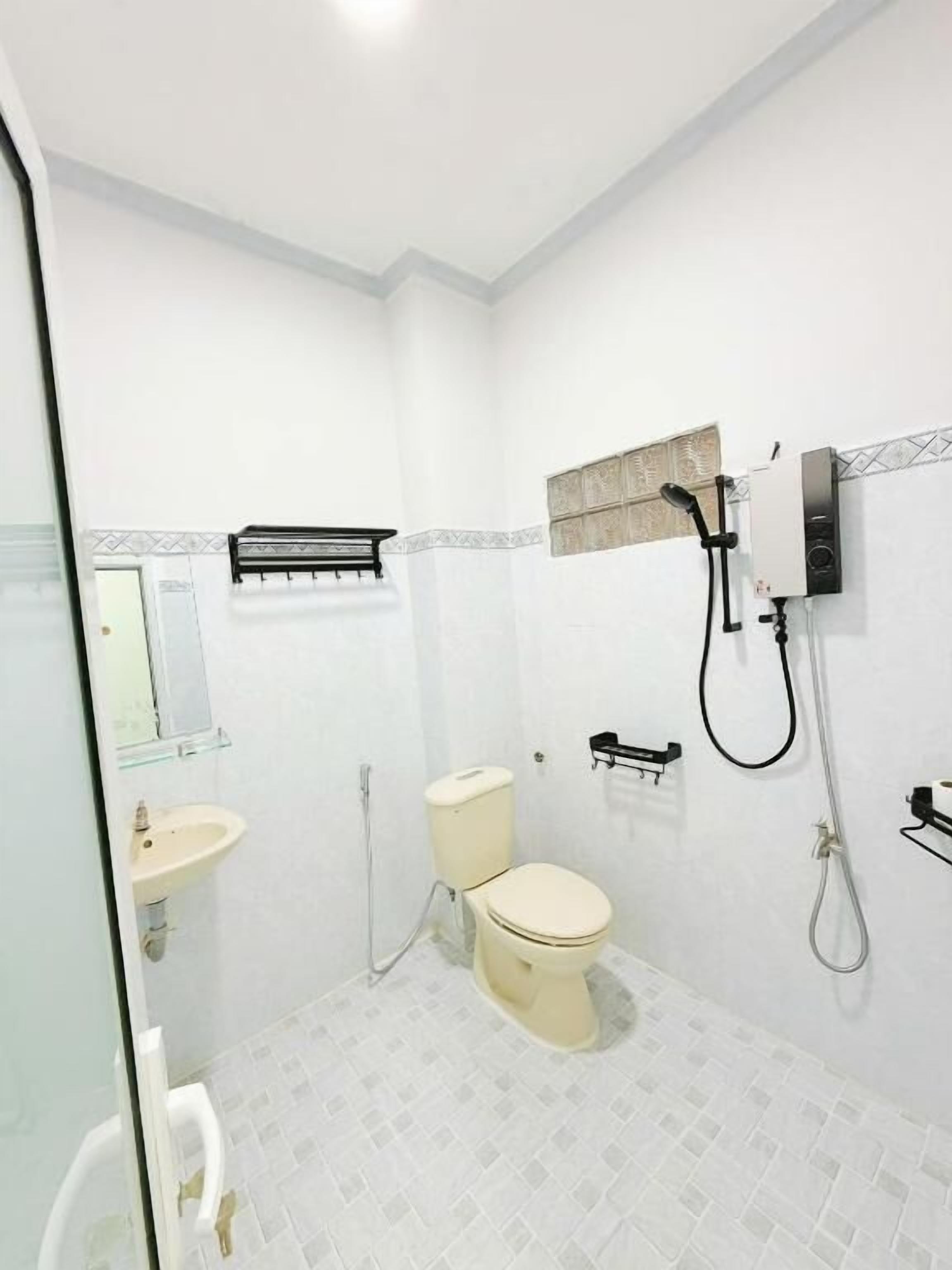 A bathroom with a toilet, sink, and shower.