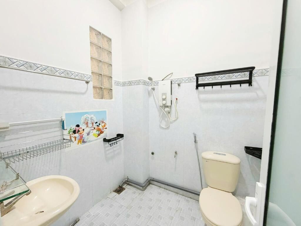 Une petite salle de bain avec des toilettes, un lavabo et une douche.