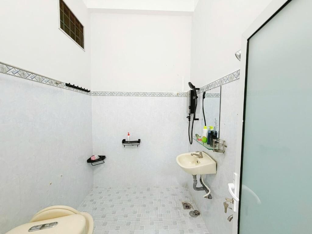 A small, compact bathroom with a toilet, sink, and shower.
