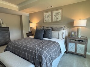 A bedroom with a bed, a nightstand, a dresser, and two wall art pieces. - Mountain retreat luxury house for rent (Washington)