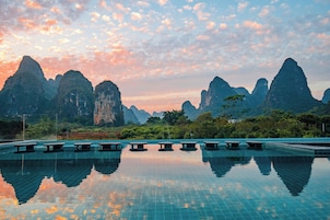 Una piscina con reflejos cristalinos, rodeada de terreno montañoso.