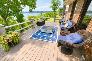 Eine Terrasse mit Gartenmöbeln, einem Laptop und einem dekorativen Teppich.