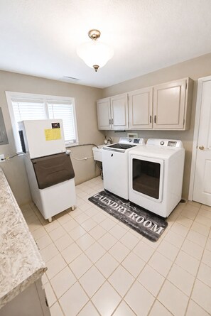 A laundry room with a washing machine, dryer, and a refrigerator.