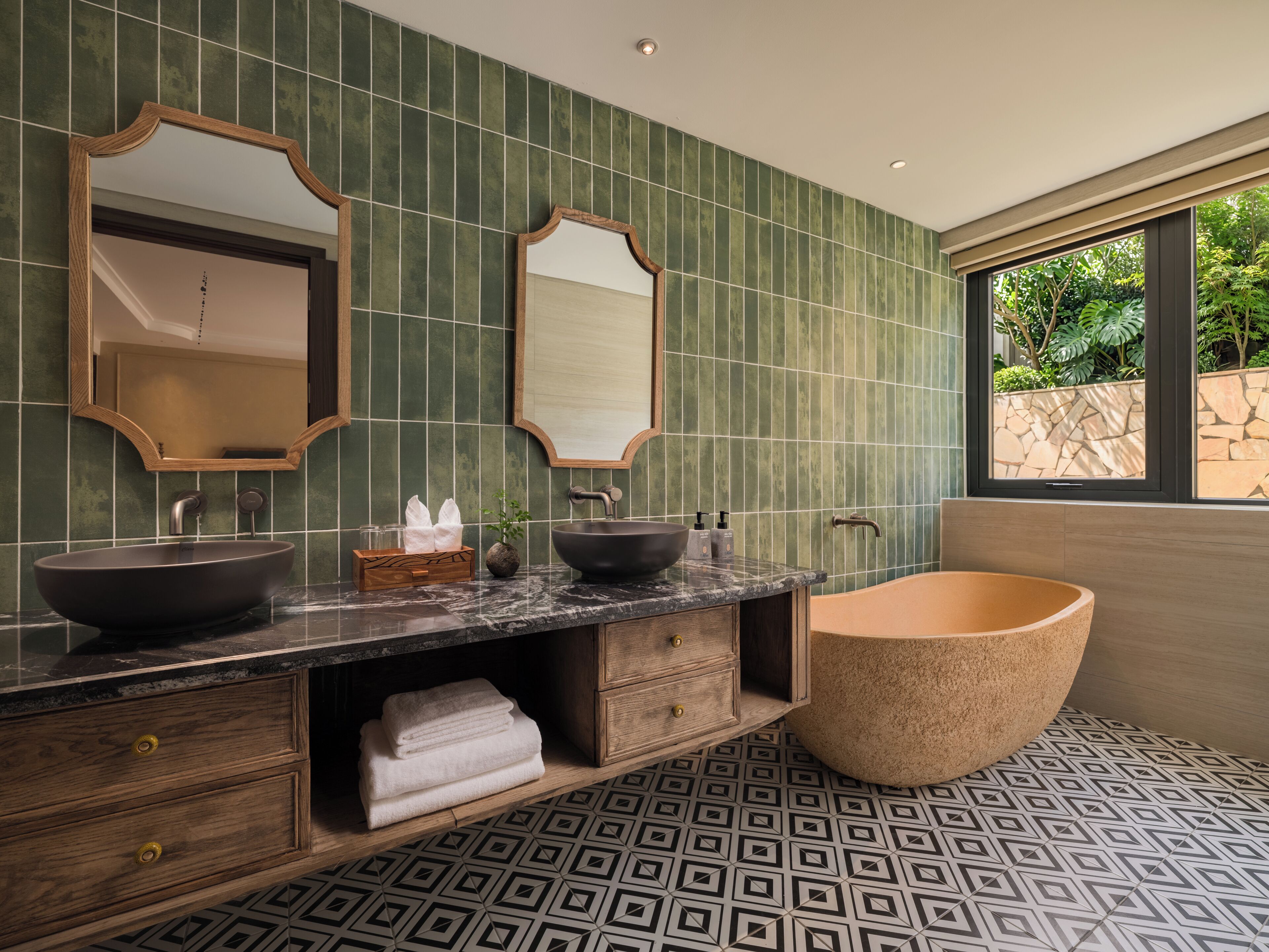 A bathroom with two sinks, a bathtub, and a large mirror.