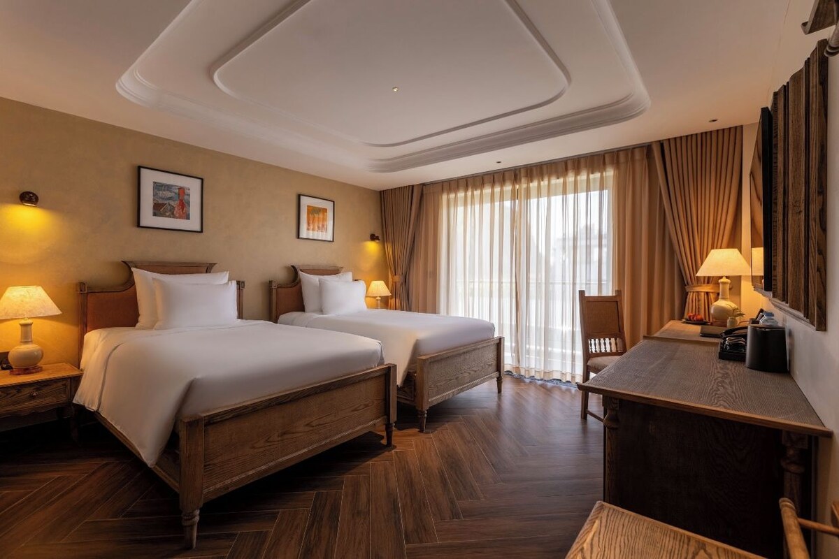 Una habitación de hotel con dos camas, un escritorio y una silla.