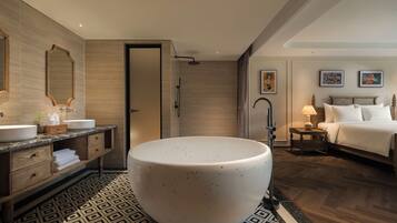 A modern bathroom with a freestanding bathtub, a vanity with a mirror, and a shower area.