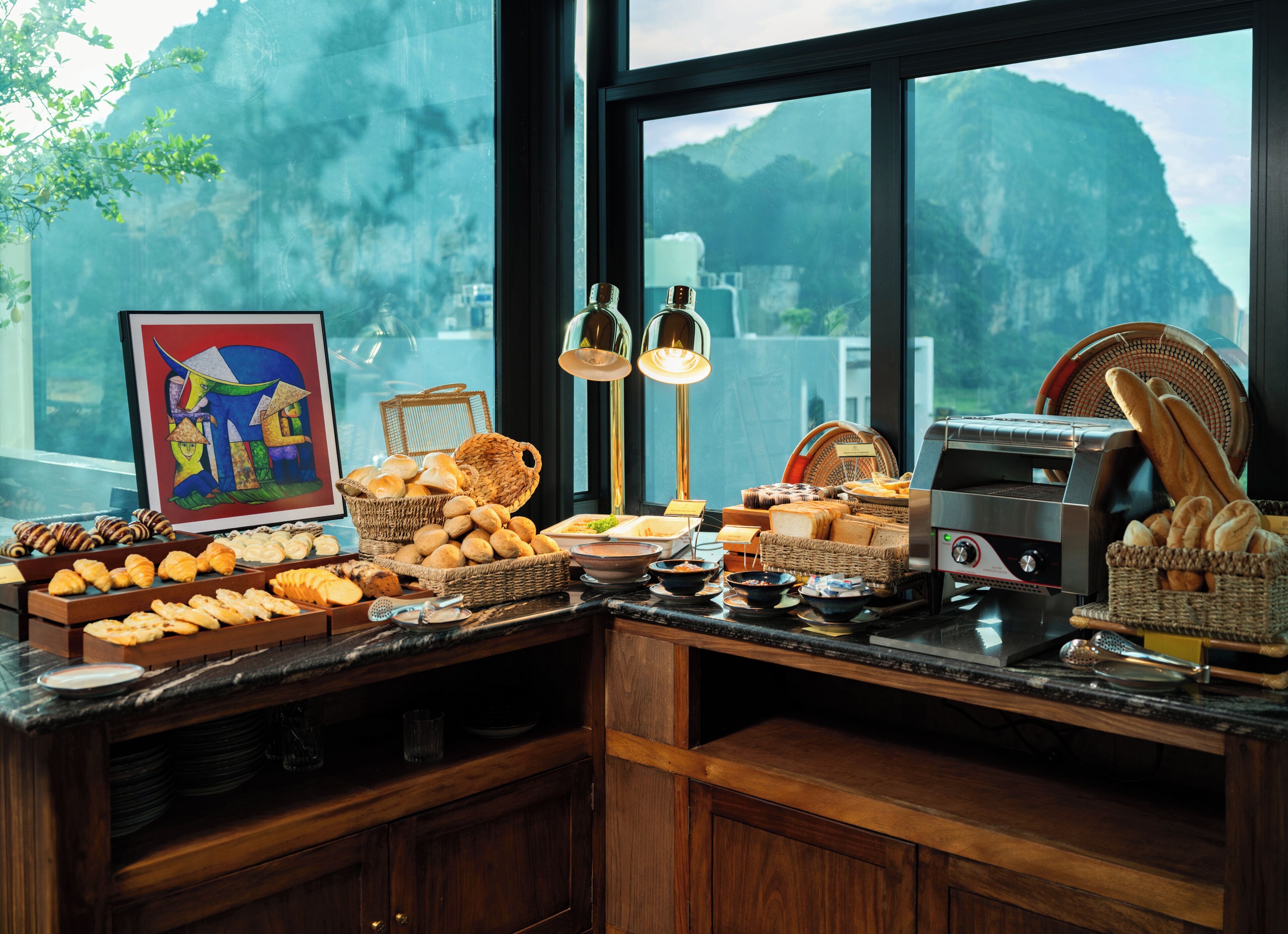 A breakfast buffet with bread, pastries, and a coffee machine.