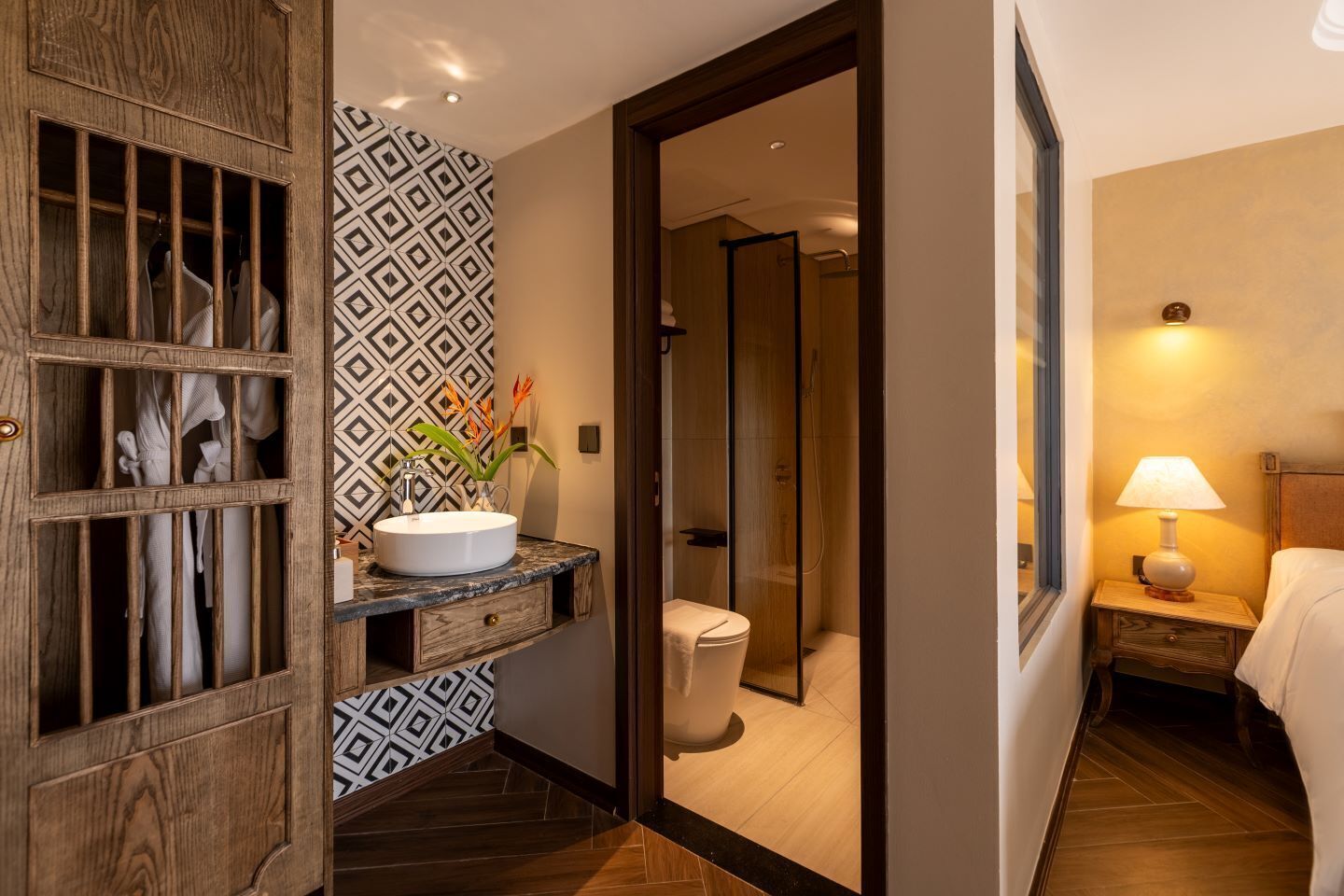A hotel bathroom with a vanity, toilet, and shower.